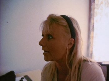 Movie still from “The Celebration” (1998), directed by Thomas Vinterberg – A woman with blonde hair wearing a black headband; Close Up shot, High angle