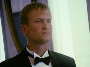 Movie still from “The Celebration” (1998), directed by Thomas Vinterberg – A person wearing a suit and bow tie; Close Up shot, Low angle