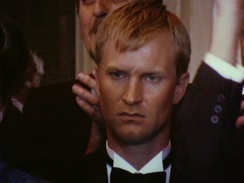 Movie still from “The Celebration” (1998), directed by Thomas Vinterberg – A person wearing a suit and a bow tie; Close Up shot, High angle
