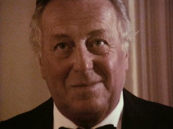 Movie still from “The Celebration” (1998), directed by Thomas Vinterberg – An older man wearing a suit and bow tie; Close Up shot, High angle