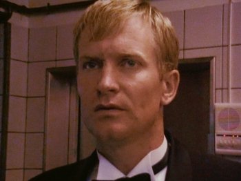 Movie still from “The Celebration” (1998), directed by Thomas Vinterberg – A person wearing a suit and bow tie; Close Up shot, Low angle