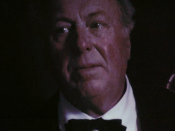 Movie still from “The Celebration” (1998), directed by Thomas Vinterberg – An older man wearing a suit and bow tie; Close Up shot, Low angle