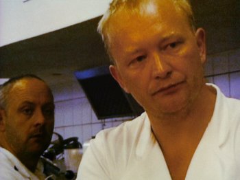 Movie still from “The Celebration” (1998), directed by Thomas Vinterberg – A man in a white shirt is looking at the camera; Close Up shot, Low angle