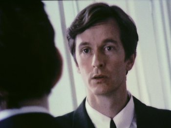 Movie still from “The Celebration” (1998), directed by Thomas Vinterberg – A man in a suit looking at himself in the mirror; Close Up shot, Low angle