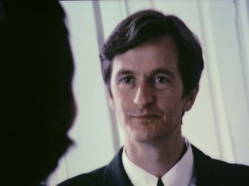Movie still from “The Celebration” (1998), directed by Thomas Vinterberg – A man wearing a suit and tie looking into a mirror; Close Up shot, Over the shoulder angle