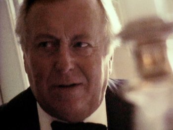 Movie still from “The Celebration” (1998), directed by Thomas Vinterberg – An older man wearing a suit and bow tie; Close Up shot, Low angle