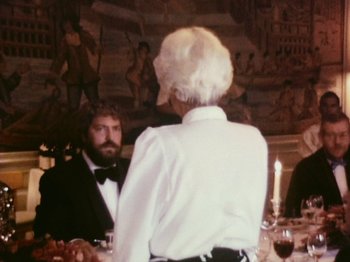 Movie still from “The Celebration” (1998), directed by Thomas Vinterberg – A man and a woman are sitting at a dinner table; Medium shot, Over the shoulder angle