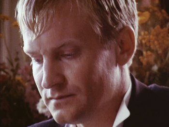 Movie still from “The Celebration” (1998), directed by Thomas Vinterberg – A person wearing a suit and tie; Close Up shot, Low angle