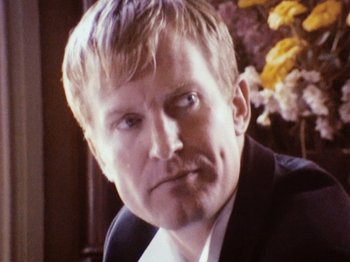 Movie still from “The Celebration” (1998), directed by Thomas Vinterberg – A person wearing a suit and tie; Close Up shot, Low angle