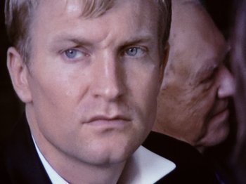 Movie still from “The Celebration” (1998), directed by Thomas Vinterberg – A person wearing a suit and tie; Close Up shot, Over the shoulder angle