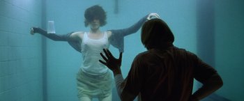 Movie still from “The Cell” (2000), directed by Tarsem Singh – A man and a woman in the water in front of one another; Medium shot, Over the shoulder angle