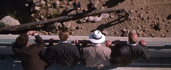 Movie still from “The Cell” (2000), directed by Tarsem Singh – A group of men sitting on a ledge; Extreme Wide shot, Overhead angle