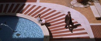 Movie still from “The Cell” (2000), directed by Tarsem Singh – A man and a woman walking down the steps of a swimming pool; Extreme Wide shot, Overhead angle
