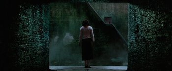 Movie still from “The Cell” (2000), directed by Tarsem Singh – A woman standing in front of a green wall; Extreme Wide shot, Low angle