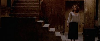 Movie still from “The Cell” (2000), directed by Tarsem Singh – A woman walking down a set of stairs; Wide shot, Low angle