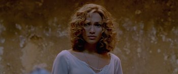 Movie still from “The Cell” (2000), directed by Tarsem Singh – A beautiful woman with curly blonde hair wearing a white shirt; Close Up shot, Low angle