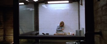 Movie still from “The Cell” (2000), directed by Tarsem Singh – A woman sitting on the ground in a room; Wide shot, High angle