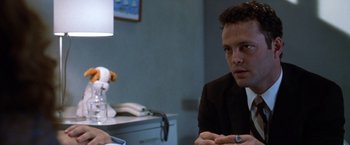 Movie still from “The Cell” (2000), directed by Tarsem Singh – A man sitting at a table in front of a lamp; Close Up shot, Over the shoulder angle