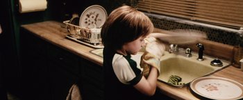 Movie still from “The Cell” (2000), directed by Tarsem Singh – A young boy is washing his hands in the kitchen; Medium shot, High angle