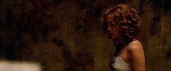Movie still from “The Cell” (2000), directed by Tarsem Singh – A woman with curly red hair standing in front of a brown wall; Medium shot, High angle