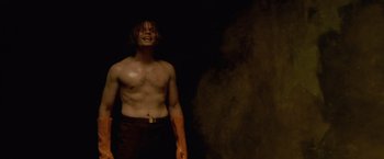 Movie still from “The Cell” (2000), directed by Tarsem Singh – A man standing in the dark with smoke coming out of his mouth; Medium shot, Low angle