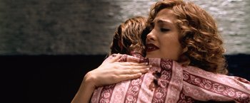 Movie still from “The Cell” (2000), directed by Tarsem Singh – A woman hugging another woman with her hands on her chest; Close Up shot, Over the shoulder angle