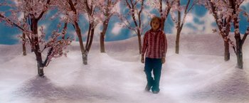Movie still from “The Cell” (2000), directed by Tarsem Singh – A boy is walking in the snow near some trees; Wide shot, High angle