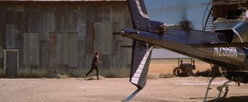 Movie still from “The Cell” (2000), directed by Tarsem Singh – A man is running in front of an airplane; Extreme Wide shot, Low angle