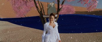 Movie still from “The Cell” (2000), directed by Tarsem Singh – A woman standing next to a tree with a sailboat in the background; Wide shot, High angle