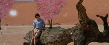 Movie still from “The Cell” (2000), directed by Tarsem Singh – A young boy standing next to a large tree trunk; Wide shot, High angle