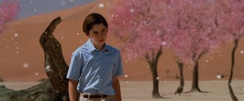 Movie still from “The Cell” (2000), directed by Tarsem Singh – A young man standing in front of a pink tree; Medium shot, Low angle