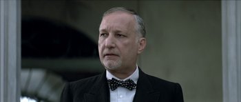 Movie still from “The Chorus” (2004), directed by Christophe Barratier – An older man wearing a suit and a bow tie; Close Up shot, Low angle