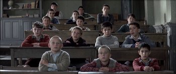 Movie still from “The Chorus” (2004), directed by Christophe Barratier – A group of young boys sitting in a class room; Medium shot, High angle
