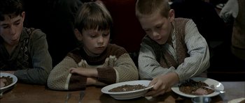 Movie still from “The Chorus” (2004), directed by Christophe Barratier – Two young boys sitting at a table with a bowl of cereal; Medium shot, High angle