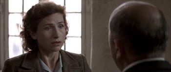 Movie still from “The Chorus” (2004), directed by Christophe Barratier – A woman in a brown jacket is talking to a man in a suit; Close Up shot, Over the shoulder angle
