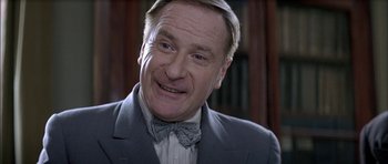 Movie still from “The Chorus” (2004), directed by Christophe Barratier – An older man wearing a suit and a bow tie; Close Up shot, Low angle