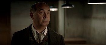 Movie still from “The Chorus” (2004), directed by Christophe Barratier – A man in a suit and tie looking to his left; Close Up shot, Over the shoulder angle