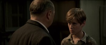 Movie still from “The Chorus” (2004), directed by Christophe Barratier – A man and a boy talking to each other; Close Up shot, Over the shoulder angle