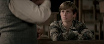 Movie still from “The Chorus” (2004), directed by Christophe Barratier – A young man sitting in front of another man; Close Up shot, Over the shoulder angle