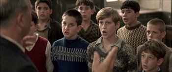 Movie still from “The Chorus” (2004), directed by Christophe Barratier – A group of young men standing next to each other; Medium shot, Over the shoulder angle