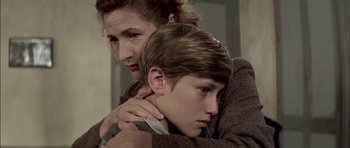 Movie still from “The Chorus” (2004), directed by Christophe Barratier – A woman and a boy are hugging each other; Close Up shot, Over the shoulder angle