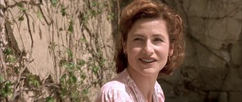 Movie still from “The Chorus” (2004), directed by Christophe Barratier – A person smiling near a tree; Close Up shot, Low angle