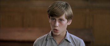 Movie still from “The Chorus” (2004), directed by Christophe Barratier – A young man with a surprised look on his face; Close Up shot, High angle