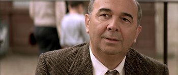 Movie still from “The Chorus” (2004), directed by Christophe Barratier – An older man wearing a brown jacket and a tie; Close Up shot, Over the shoulder angle