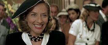 Movie still from “The Chorus” (2004), directed by Christophe Barratier – A group of people standing in a line with a woman smiling; Close Up shot, Over the shoulder angle
