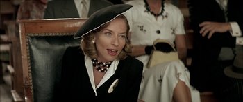 Movie still from “The Chorus” (2004), directed by Christophe Barratier – A woman wearing a black hat and a black suit; Close Up shot, Over the shoulder angle