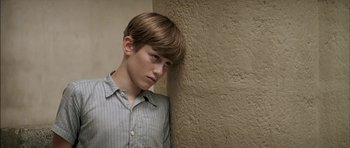 Movie still from “The Chorus” (2004), directed by Christophe Barratier – A young man leaning against a wall with his head on the wall; Close Up shot, High angle