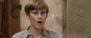 Movie still from “The Chorus” (2004), directed by Christophe Barratier – A young man with a surprised look on his face; Close Up shot, Over the shoulder angle