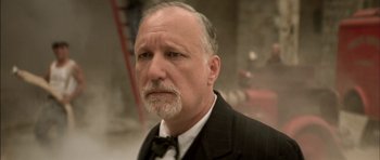 Movie still from “The Chorus” (2004), directed by Christophe Barratier – An older man in a black suit and a white beard; Close Up shot, Low angle