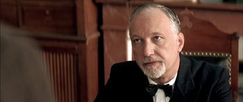 Movie still from “The Chorus” (2004), directed by Christophe Barratier – An older man wearing a tuxedo and a bow tie; Close Up shot, Low angle